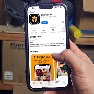 Hand holding iPhone displaying SnapSort AI app page on the App Store, with 5.0 rating and previews